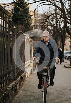 An elderly gentleman enjoys a serene bike ride along a city lane, showcasing active lifestyle and fitness in the golden