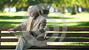 Elderly gentlemen reading news, thinking about political situation, outdoors