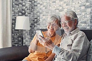 Elderly grandfather and grandmother spend time having fun using smartphone apps, middle-aged wife enjoy online entertainments,