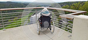 Elderly grandmother in wheelchair with granddaughter in spring nature.