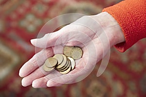 Elderly hand holding money cash loose change coins pence copper pension savings