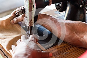 Elderly hand with a sewing machine.