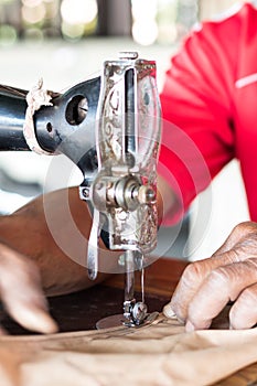 Elderly hand with a sewing machine.