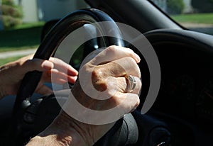 Elderly hand on steering wheel