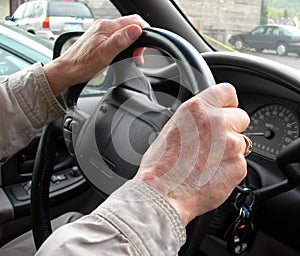 Elderly hands on steering wheel