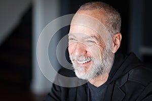 Elderly Handsome Man Smiling Away. With a gray beard. At his office