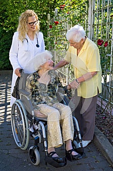 Elderly with her Doctor Talking to her Caregiver