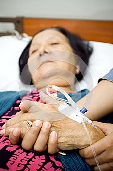 Elderly holding hands in sickness photo