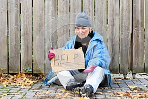 Elderly homeless woman begging on the street