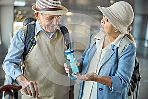 Elderly lady with a bottle talking to her husband