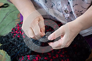 Elderly lady doing sewing hand work with needle and thread