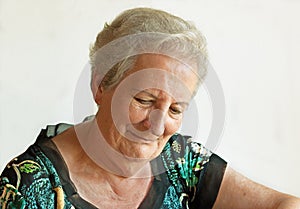 Elderly lady with downcast eyes