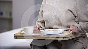 Elderly lady eating diabetic dinner in rehabilitation center, social security