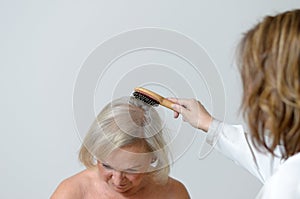 Elderly lady gets her hair combed
