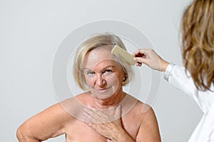 Elderly lady gets her hair combed