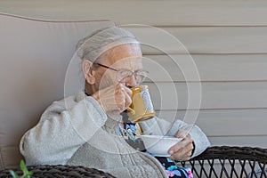 Elderly lady with a hairnet drinking out of a coffee cup