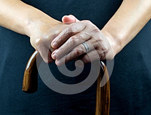 Elderly Lady Holding Walking Stick with Both Hands