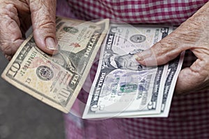 An elderly lady holds 20 dollars