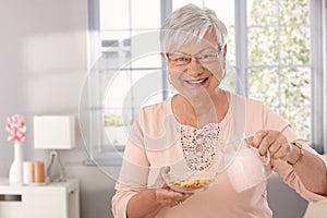 Elderly lady preparing breakfast cereal