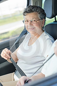 Elderly lady putting on seatbelt