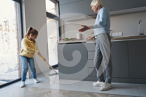 Elderly lady teaching her granddaughter to help with household duties