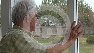 Elderly Lonely Man Looking Hopefully Out Window From Home