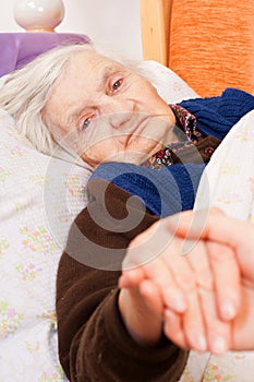 Elderly lonely woman rests in the bed
