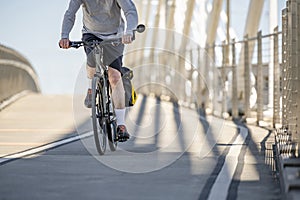 An elderly male amateur cyclist takes a bike ride on a dedicated bike path on a bridge