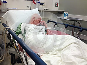 Elderly male hospital patient in hospital bed