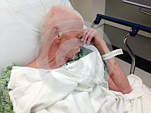 Elderly male hospital patient in hospital bed photo