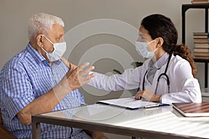 Elderly male patient in facemask consult at doctors office