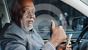 Elderly male sitting in car counting cash payment wages mature african american businessman calculates income successful