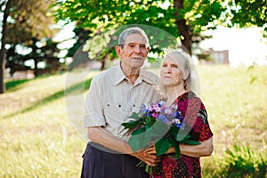 An elderly man of 80 years old gives flowers to his wife