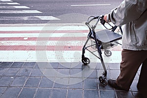 Elderly man alone disabled, using a walker to help him walk