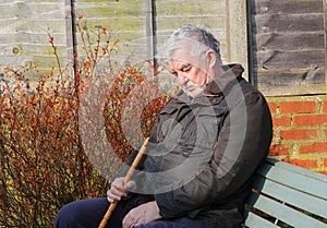 Elderly man asleep in the sunshine.