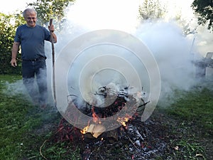 Elderly man with autumn bonfire