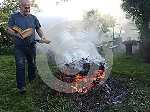 Elderly man with autumn bonfire