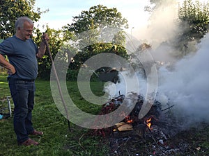 Elderly man with autumn bonfire