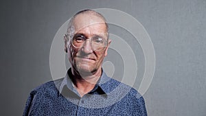 Elderly man with bad eyesight wears elegant glasses smiling