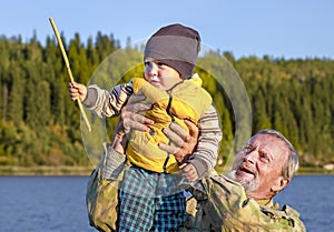 An elderly man with a beard plumped a child up above himself.