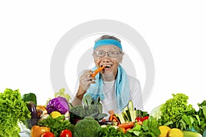 Elderly man biting carrot on studio