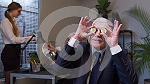 Elderly man boss dancing, fooling around, making silly faces with bitcoin coints eyes in office