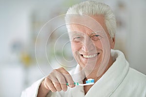 Elderly man brushing his teeth