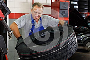 Mechanician removing tire from wheel disc photo