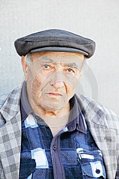 Elderly man in checkered jacket and cap