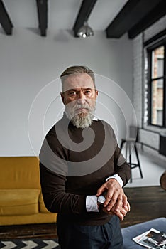 Elderly man correct wristwatch and look at camera