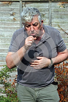 Elderly man coughing. smoking.