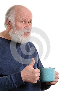 Elderly man with cup of bad tea or coffee showing thumb up isolated on white