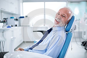 Elderly man in dentist`s chair without fear waiting for treatmen