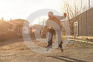 Elderly man does stunts on skateboards regardless of age. Concept of elderly man with youthful attitude